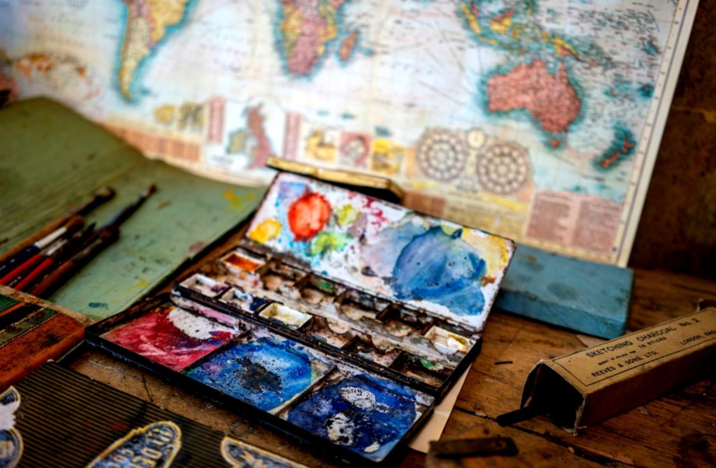 Kreative Illustration Arbeitsplatz mit verschiedenen Zeichenmaterialien und Kunstwerken